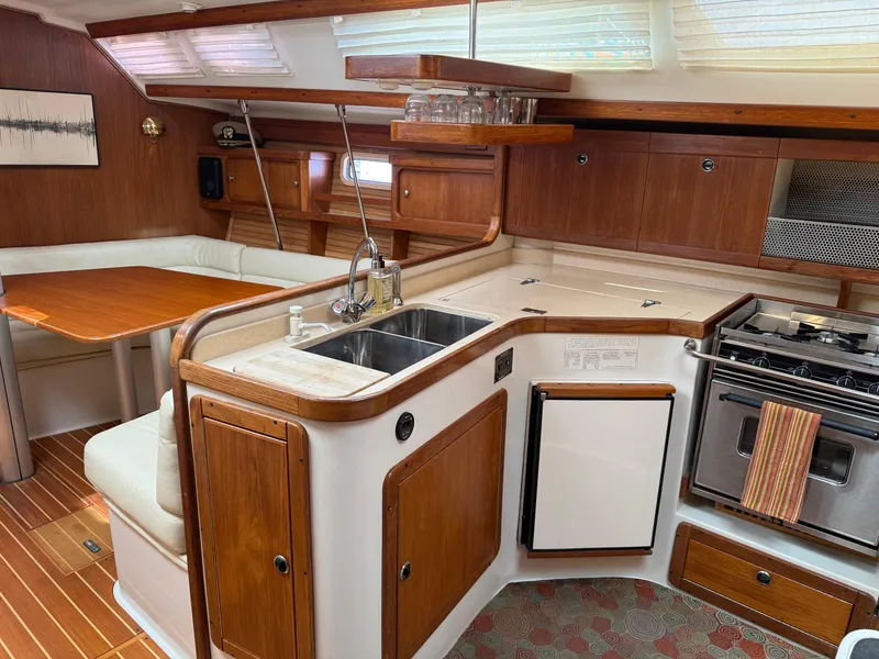 Slide: The Image of Interior of a 1998 Catalina 400 yacht featuring a kitchen and dining area. - 14