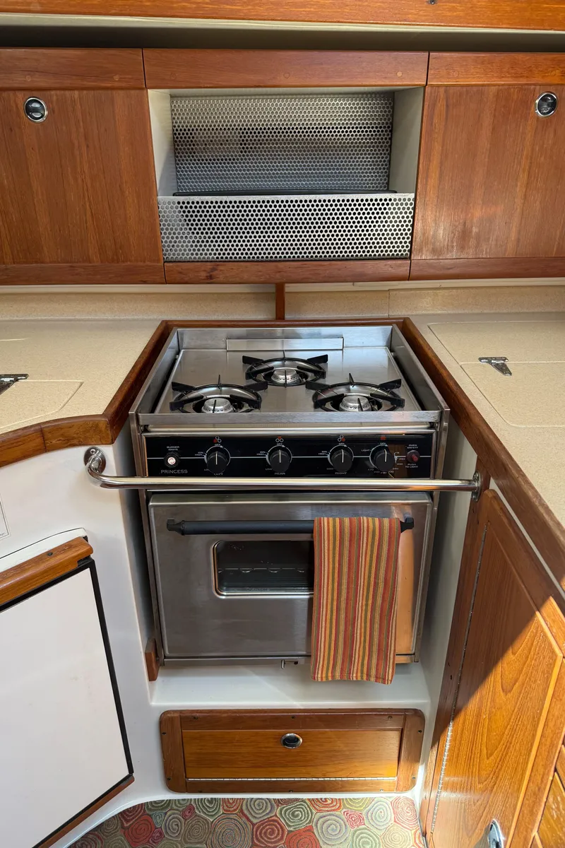 Slide: The Image of Catalina 400 yacht kitchen with stove and oven, wooden cabinets, 1998 model. - 15