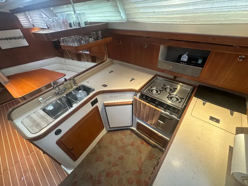 Slide: The Image of Interior of 1998 Catalina 400 yacht kitchen with stove, sink, and wooden cabinetry. - 18