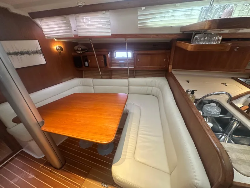 Slide: The Image of Interior of 1998 Catalina 400 sailboat with wooden table and white cushioned seating. - 33