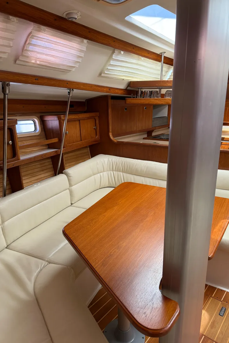Slide: The Image of Interior of a 1998 Catalina 400 sailboat with wooden table and cream seating. - 34
