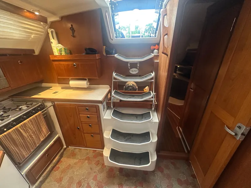 Slide: The Image of Interior of a 1998 Catalina 400 sailboat with wooden cabinetry and compact kitchen. - 36