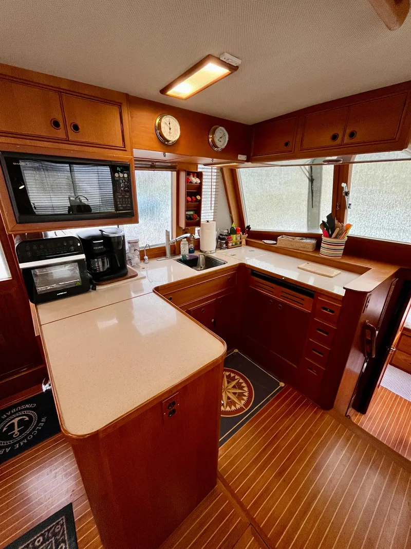 Slide: The Image of 1997 Grand Banks 49 Classic yacht kitchen with wood cabinetry and modern appliances. - 14