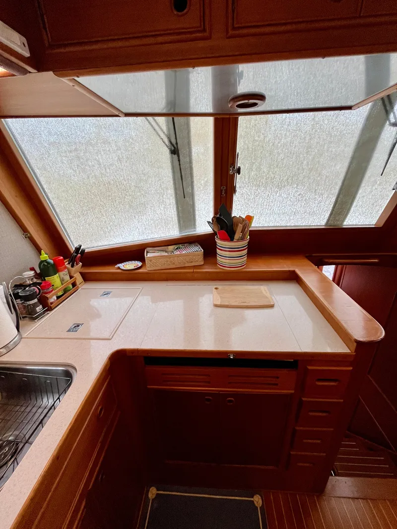 Slide: The Image of 1997 Grand Banks 49 Classic yacht kitchen with wooden cabinetry and countertop. - 16