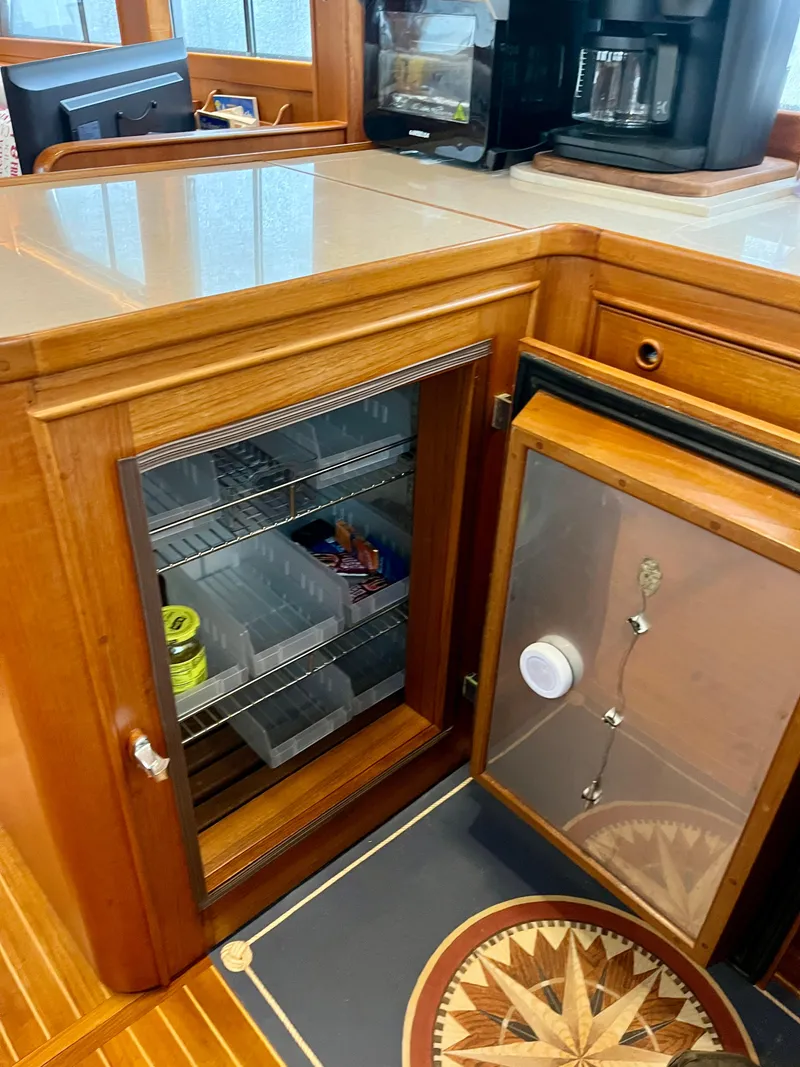 Slide: The Image of 1997 Grand Banks 49 Classic yacht interior with wooden cabinetry and mini fridge. - 19