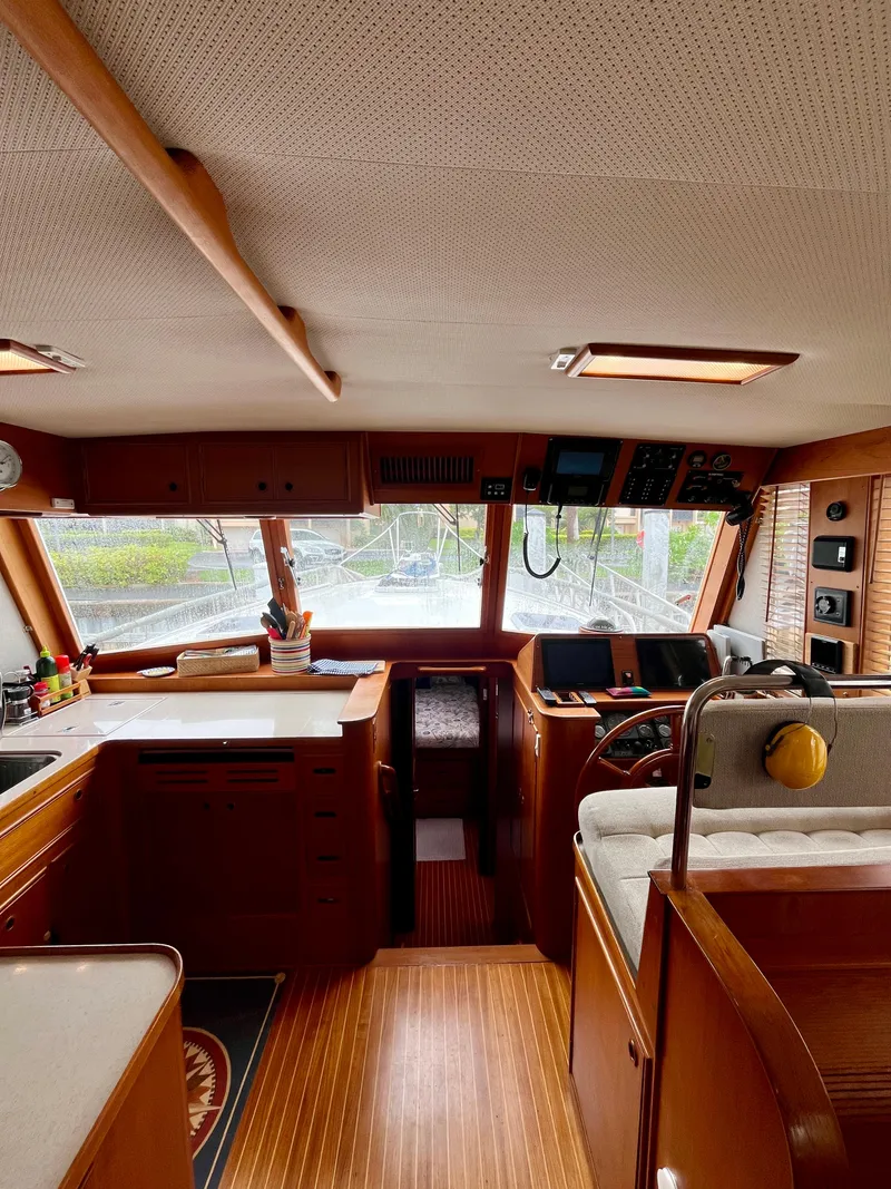Slide: The Image of Interior of a 1997 Grand Banks 49 Classic yacht, featuring a wooden helm and kitchen area. - 20