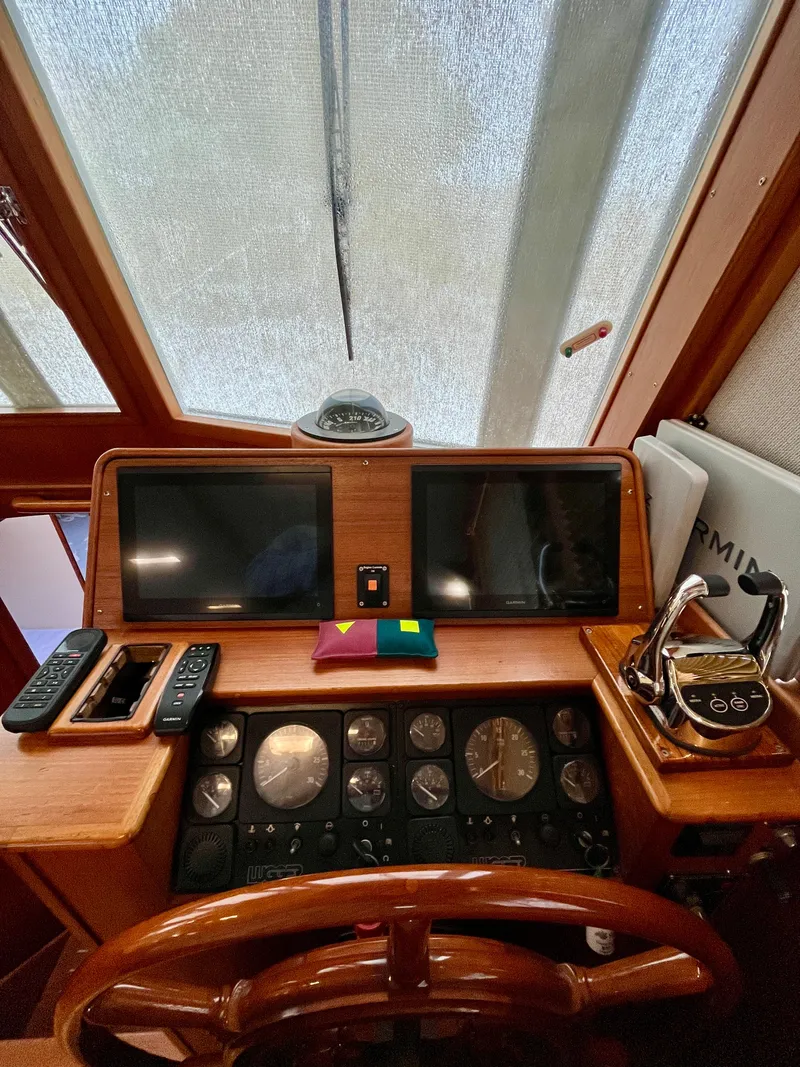 Slide: The Image of Helm of 1997 Grand Banks 49 Classic yacht with navigation instruments and wooden steering wheel. - 23