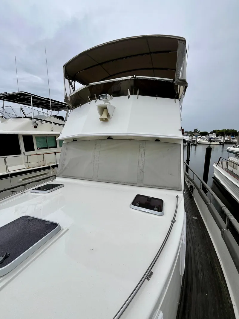 Slide: The Image of 1997 Grand Banks 49 Classic yacht docked at marina, featuring spacious deck and covered flybridge. - 3