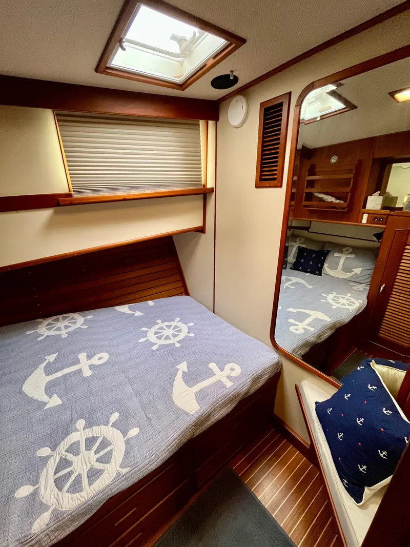 Slide: The Image of 1997 Grand Banks 49 Classic cabin with nautical-themed bedding and wooden interior. - 30