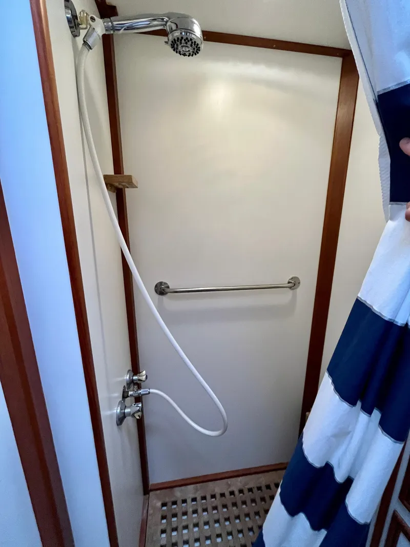Slide: The Image of Shower area in a 1997 Grand Banks 49 Classic yacht with striped curtain and handheld showerhead. - 37