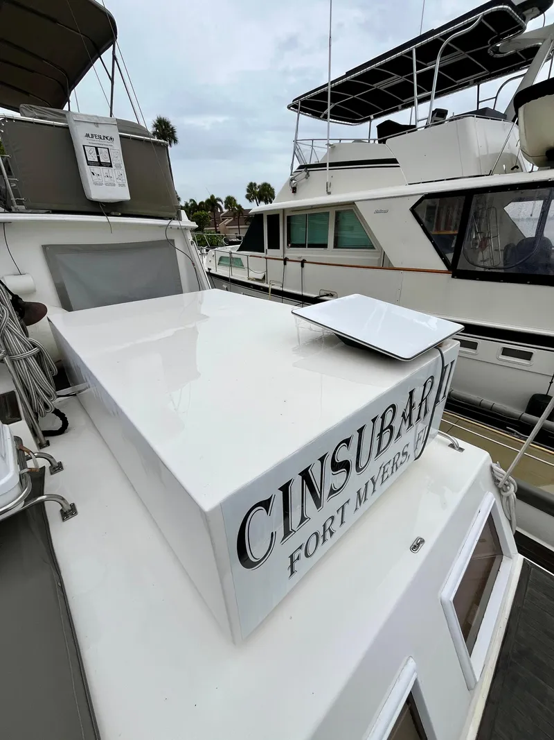 Slide: The Image of 1997 Grand Banks 49 Classic yacht docked, featuring "CINSUBAR" and "FORT MYERS" on the stern. - 42