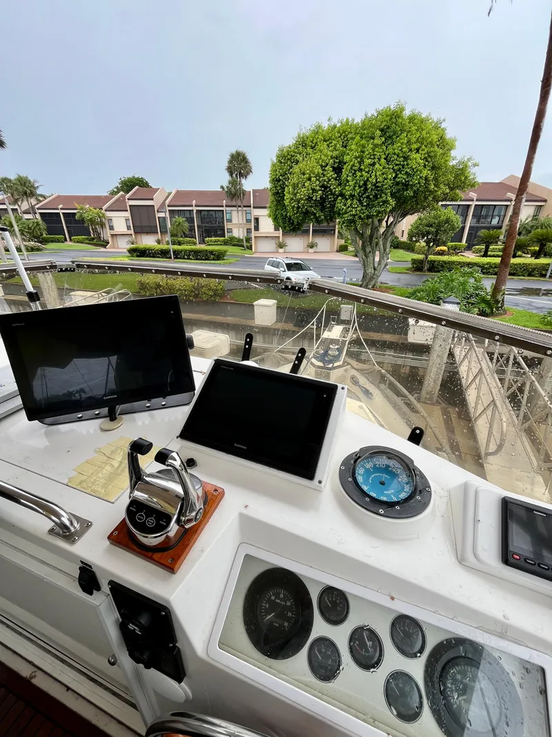 Slide: The Image of 1997 Grand Banks 49 Classic helm with navigation equipment, overlooking a marina and residential area. - 49
