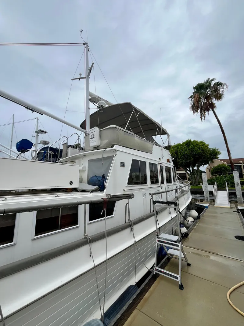 Slide: The Image of 1997 Grand Banks 49 Classic yacht docked, showcasing elegant design and spacious deck. - 5