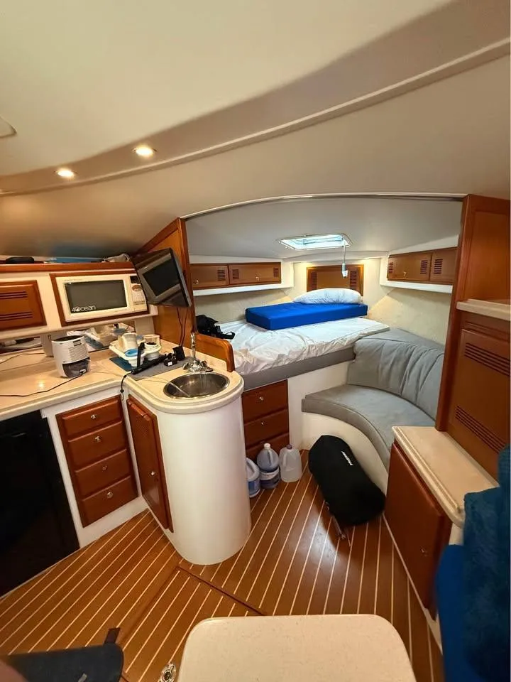 Slide: The Image of 2001 Cabo 35 Express cabin interior with kitchenette, bed, and seating area. - 14
