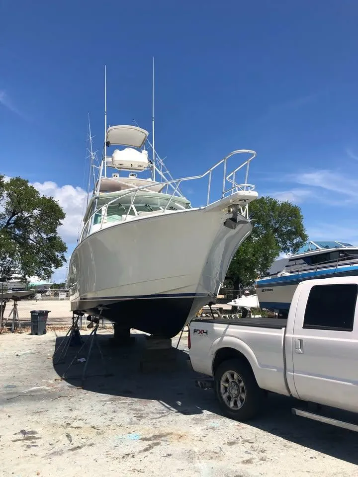 Slide: The Image of 2001 Cabo 35 Express boat on dry dock beside a white truck. - 16