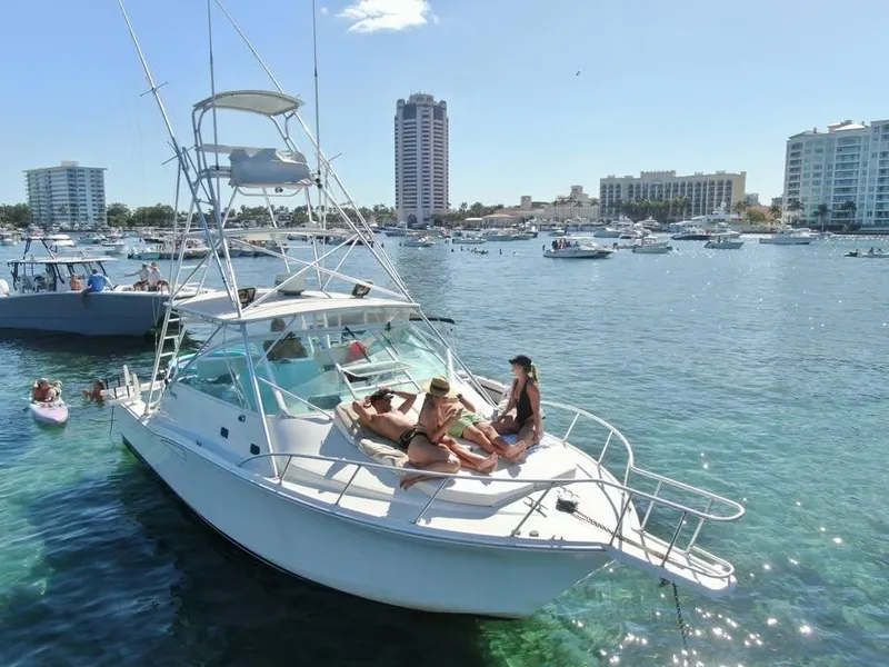 Slide: The Image of 2001 Cabo 35 Express yacht with people relaxing, docked in a busy marina. - 2