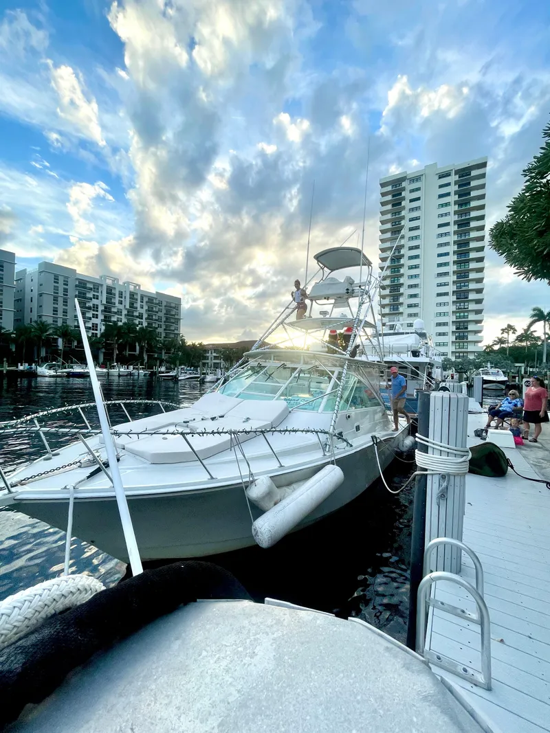 Slide: The Image of 2001 Cabo 35 Express yacht docked at marina with cityscape and cloudy sky. - 3