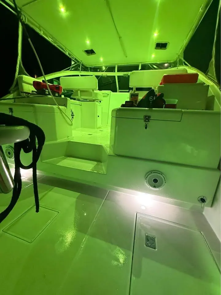 Slide: The Image of 2001 Cabo 35 Express boat interior with green lighting and seating area. - 9