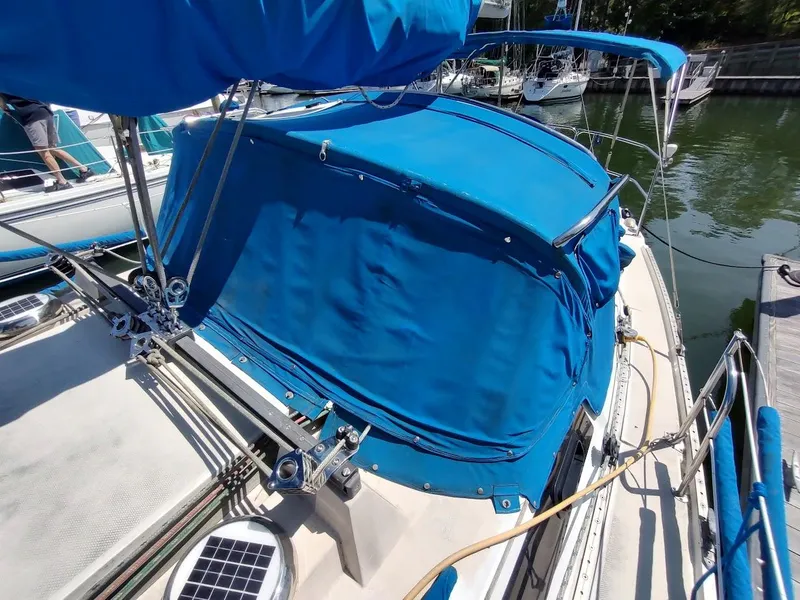 Slide: The Image of 1987 Catalina C-34 sailboat with blue canvas cover docked at marina. - 11