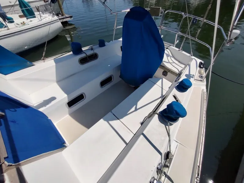 Slide: The Image of 1987 Catalina C-34 sailboat cockpit with blue covers, docked on calm water. - 12