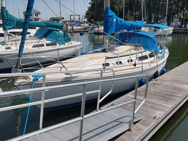 Slide: The Image of 1987 Catalina C-34 sailboat docked at marina with blue covers and fenders. - 2