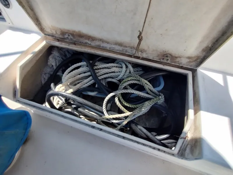 Slide: The Image of Open storage compartment on 1987 Catalina C-34 sailboat with coiled ropes inside. - 28