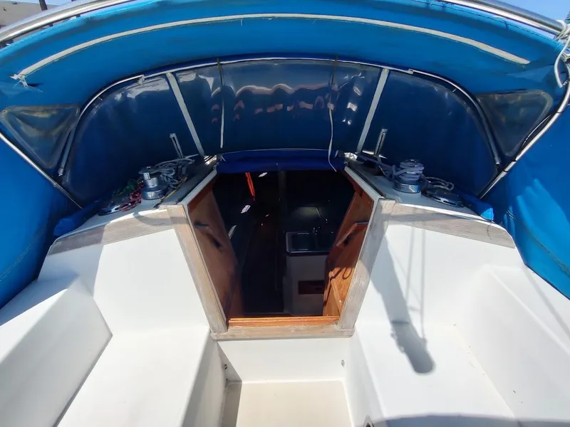 Slide: The Image of 1987 Catalina C-34 sailboat cockpit with blue canopy and wooden cabin entrance. - 29