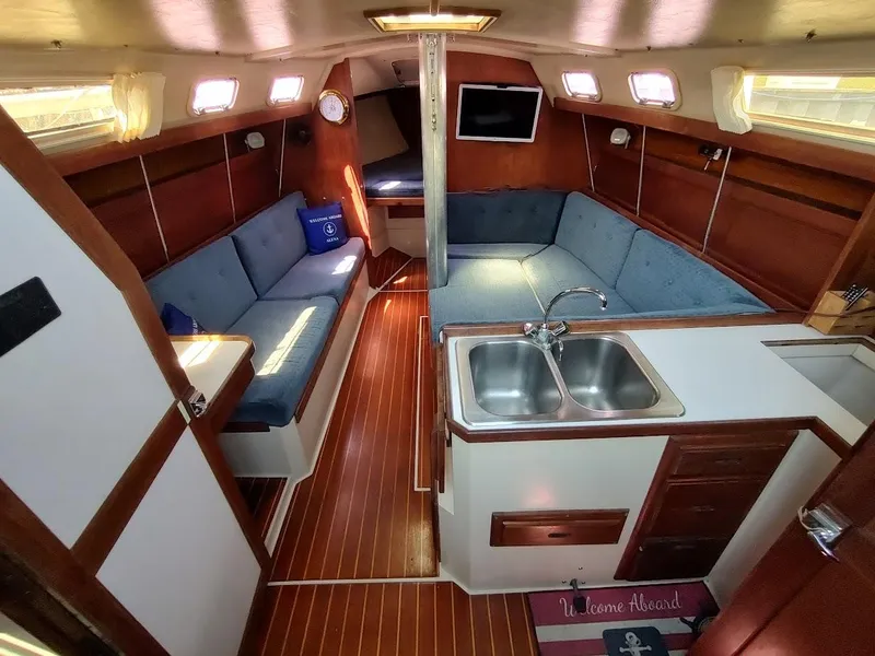Slide: The Image of Interior of 1987 Catalina C-34 sailboat with cozy seating and kitchen area. - 30
