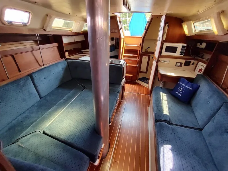 Slide: The Image of Interior of 1987 Catalina C-34 sailboat with blue seating and wooden flooring. - 31