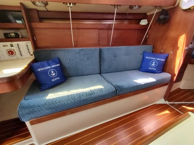 Slide: The Image of Interior of 1987 Catalina C-34 sailboat with blue cushions and "Welcome Aboard" pillows. - 34