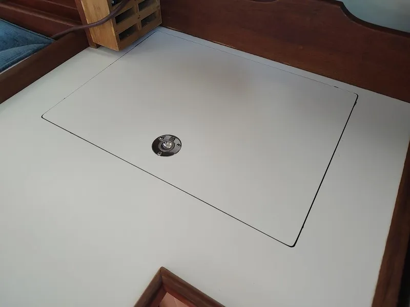 Slide: The Image of 1987 Catalina C-34 interior compartment with wooden trim and secure latch. - 38