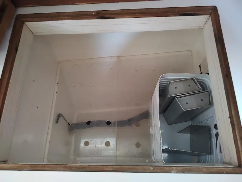 Slide: The Image of Empty storage compartment in a 1987 Catalina C-34 sailboat with metal brackets. - 39