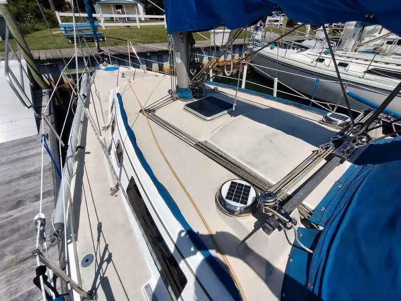 Slide: The Image of 1987 Catalina C-34 sailboat docked, featuring blue canvas covers and deck equipment. - 4