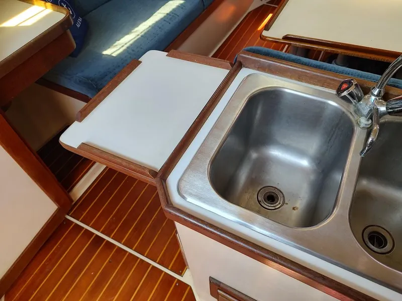 Slide: The Image of Interior of 1987 Catalina C-34 sailboat showing kitchen sink and wooden flooring. - 41
