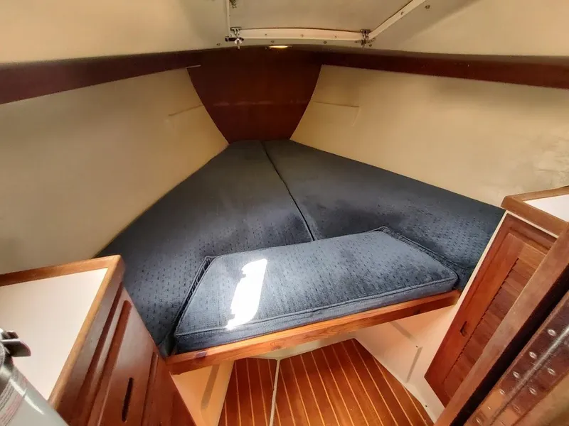 Slide: The Image of 1987 Catalina C-34 sailboat interior cabin with blue cushions and wooden accents. - 46