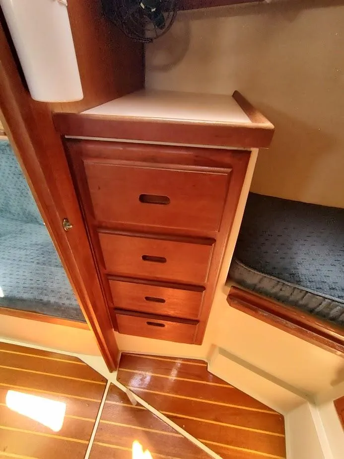 Slide: The Image of 1987 Catalina C-34 interior with wooden drawers and cushioned seating. - 49