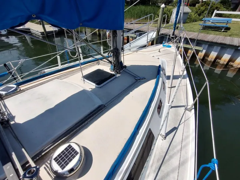 Slide: The Image of 1987 Catalina C-34 sailboat deck with blue cover, docked at marina. - 5