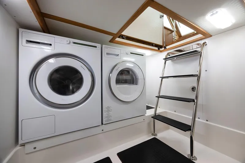 Slide: The Image of Laundry area with washer, dryer, and ladder in 2026 Sabre 45 Salon Express yacht. - 14