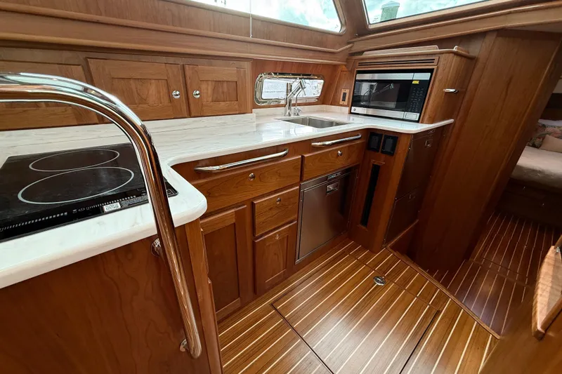 Slide: The Image of Luxurious 2026 Sabre 45 Salon Express yacht kitchen with wood cabinetry and modern appliances. - 18