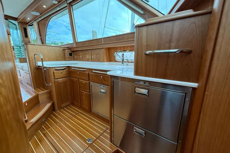 Slide: The Image of Luxurious 2026 Sabre 45 Salon Express yacht kitchen with wood cabinetry and stainless steel appliances. - 19