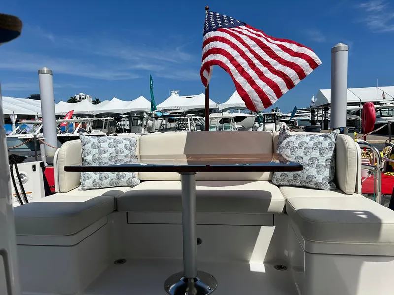 Slide: The Image of 2026 Sabre 45 Salon Express yacht deck with seating and wooden table. - 2