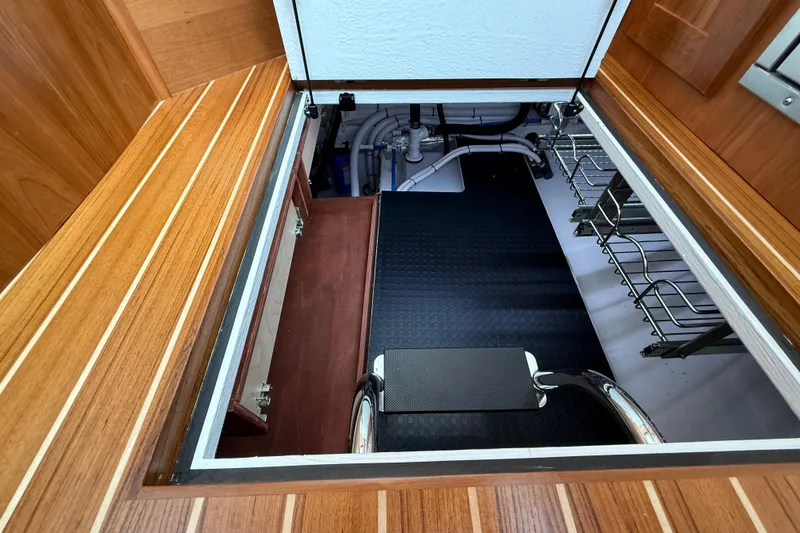 Slide: The Image of Engine room access on 2026 Sabre 45 Salon Express yacht, featuring wooden flooring and storage racks. - 21