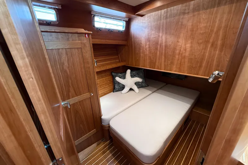 Slide: The Image of 2026 Sabre 45 Salon Express cabin with wooden interior and cozy bedding. - 23