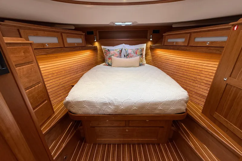 Slide: The Image of Luxurious 2026 Sabre 45 Salon Express cabin with elegant wood finish and cozy bedding. - 26