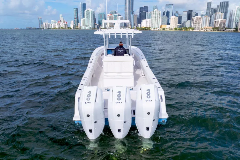 Slide: The Image of 2025 Invincible 36 Open boat with triple engines cruising near city skyline. - 1