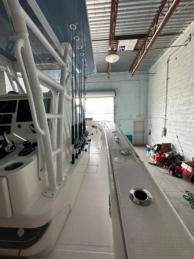 Slide: The Image of 2025 Invincible 36 Open boat in a garage, showcasing fishing rod holders and sleek design. - 11