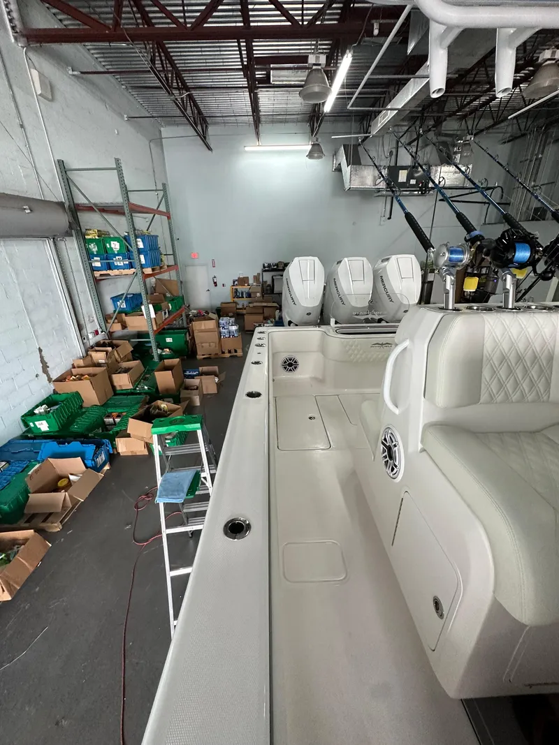 Slide: The Image of 2025 Invincible 36 Open boat in warehouse with equipment and supplies. - 13