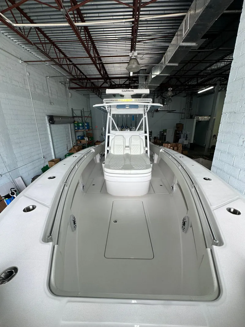 Slide: The Image of 2025 Invincible 36 Open boat in a warehouse, showcasing sleek design and spacious deck. - 5