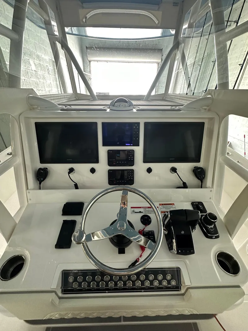 Slide: The Image of 2025 Invincible 36 Open boat dashboard with dual screens and modern controls. - 9