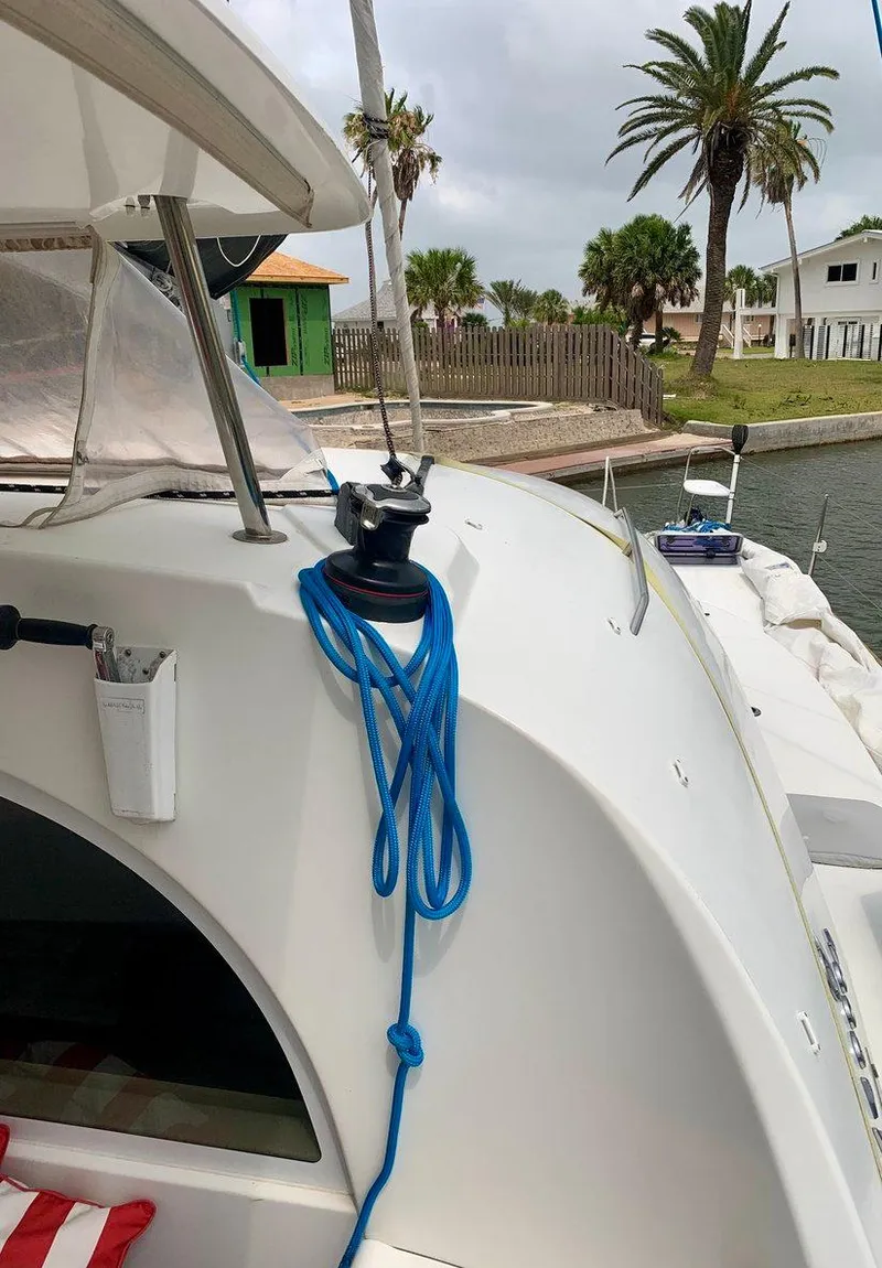 Slide: The Image of Lagoon 380 S2 4/2 catamaran, 2019 model, docked with blue rope on deck. - 12